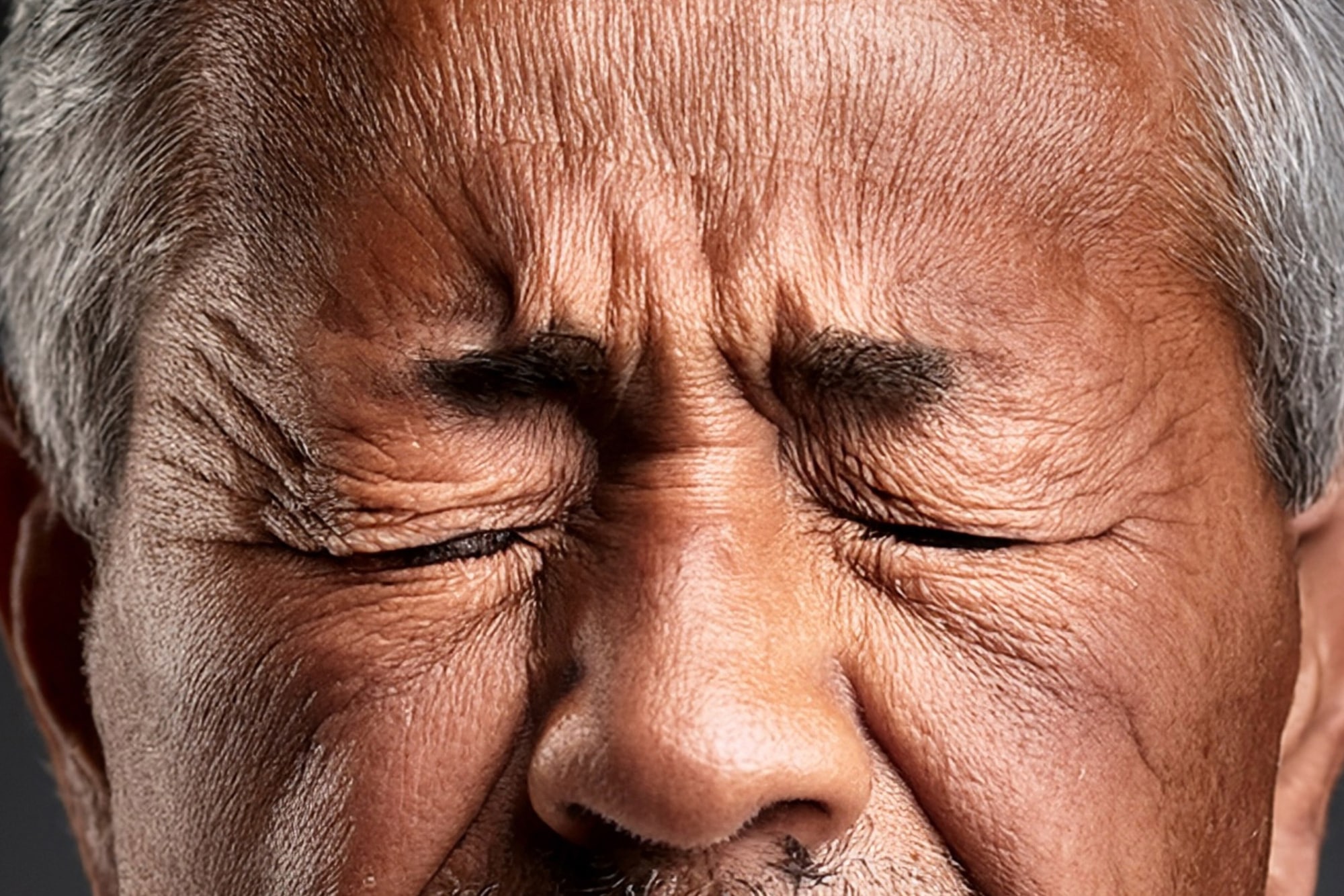 Man scrunching face in pain while having a poo