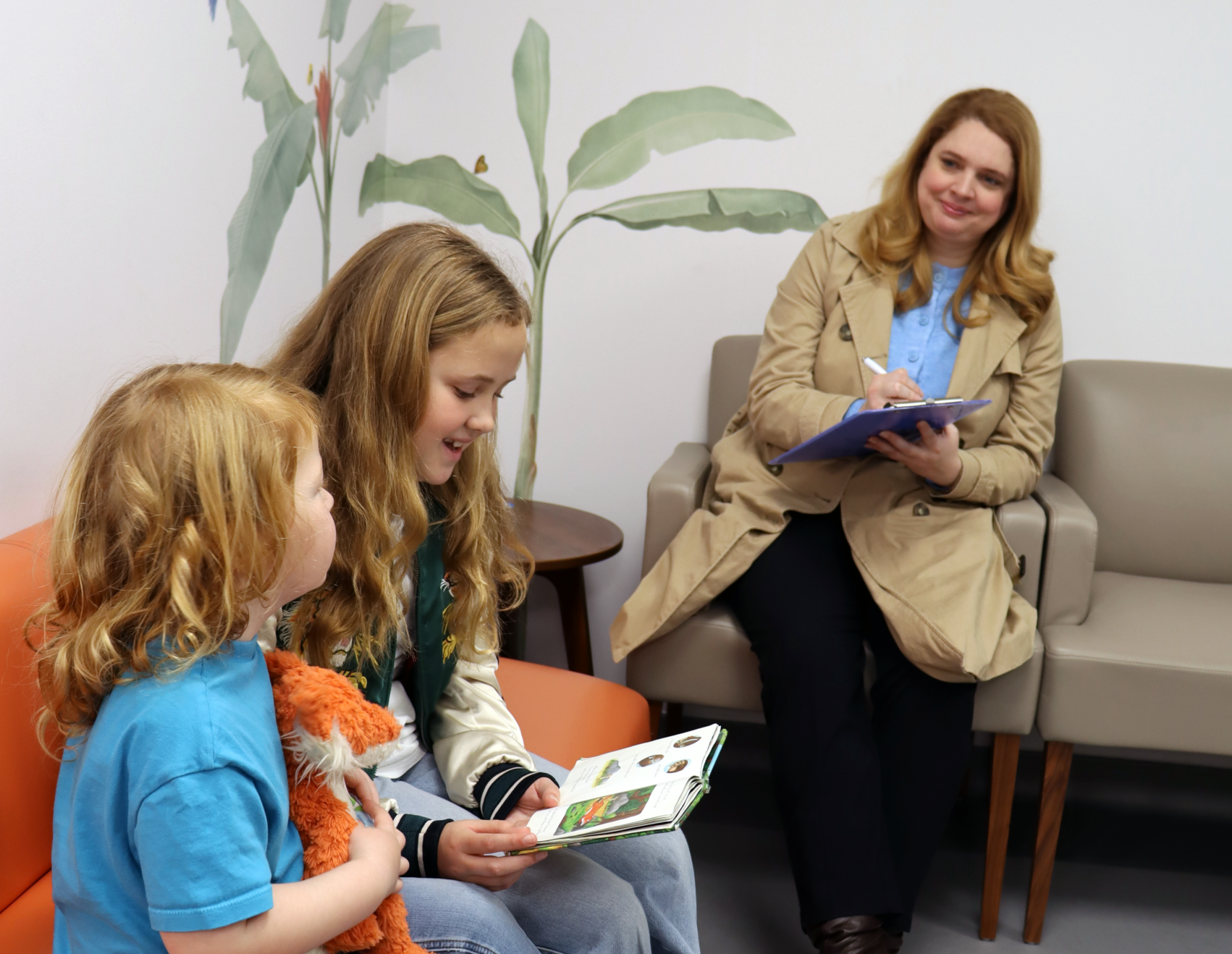 Parent sites with her children who are ill and waiting to be seen by a paediatrician in London