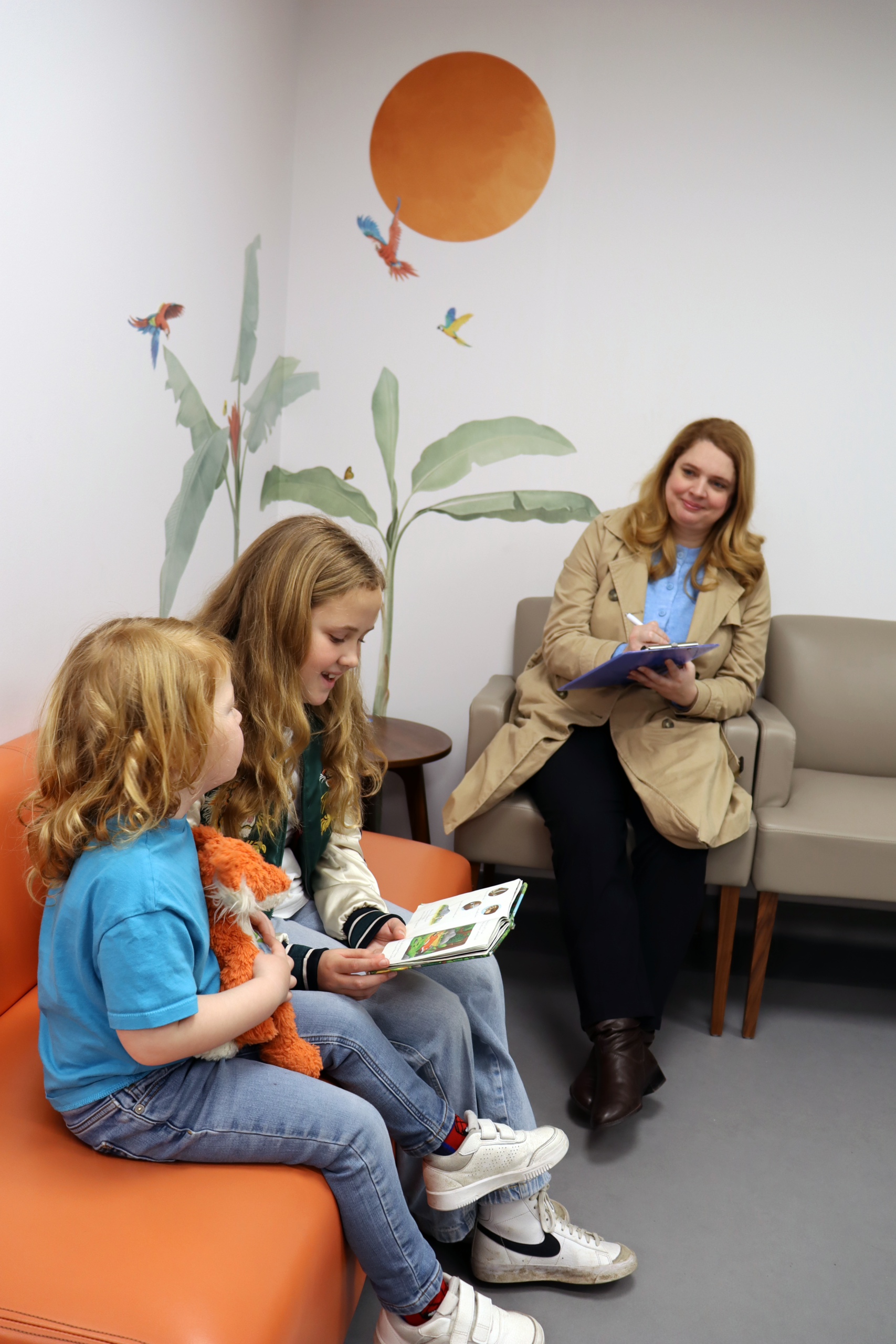 Parent sites with her children who are ill and waiting to be seen by a paediatrician in London